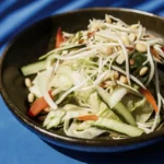 Salade thaï élégante avec légumes frais, herbes aromatiques, et protéines grillées, servie dans un grand bol.