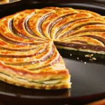 Galette des rois chocolat dorée et croustillante sur une table décorée, prête à être servie.