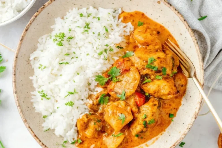Plat de riz au poulet et curry avec des morceaux de poulet tendre dans une sauce curry dorée, accompagné de riz basmati parfumé, garni de coriandre fraîche.
