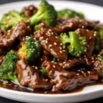 plat de bœuf au brocoli servi dans un plat sur une table élégante, avec une présentation appétissante.
